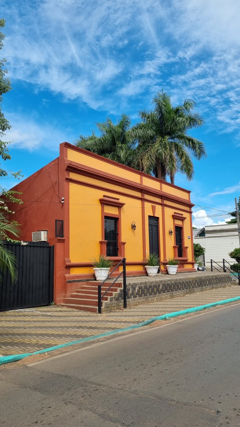 Kolonial geprägtes Haus mit orangefarbener Putzfassade und Zierleisten
