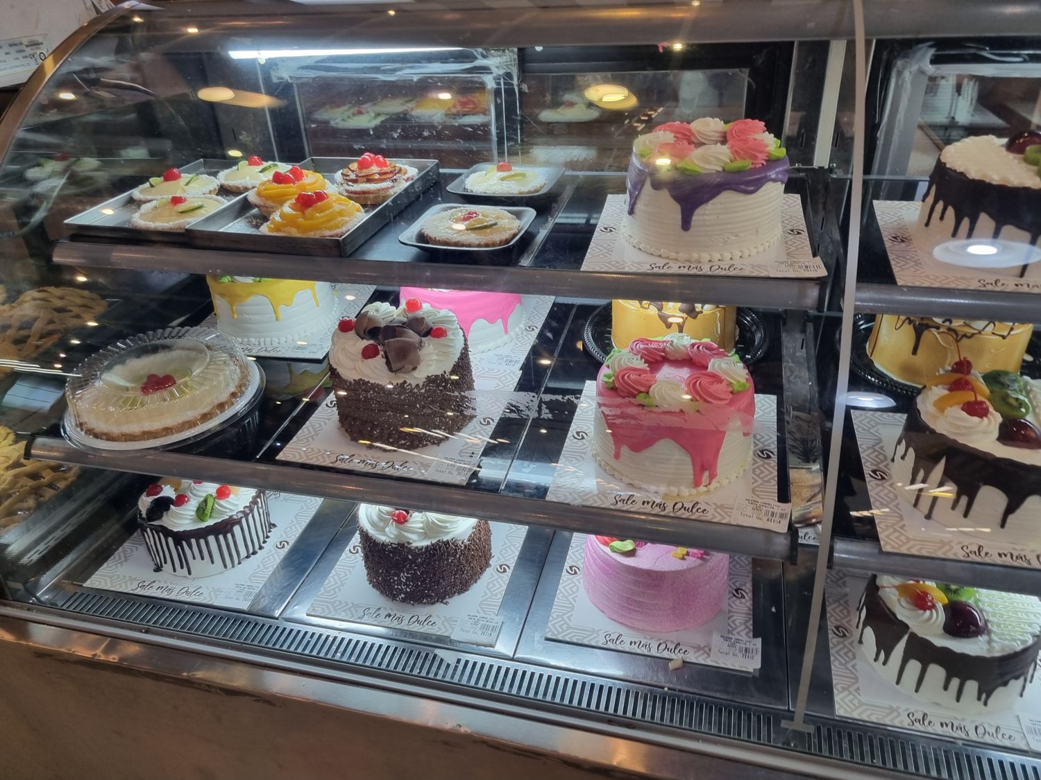 Kühlvitrine mit bunt verzierten Torten und Obsttörtchen