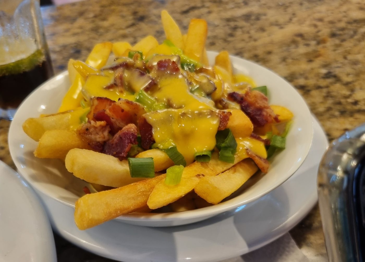 Pommes mit Käsesauce, Speck und Frühlingszwiebeln
